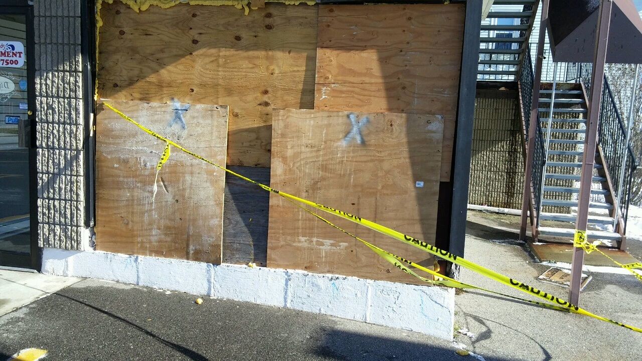 Boarded up display window after commercial vandalism
